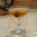 Whiskey/Negroni Barrel Aged Tequila Manhattan Amber cocktail in coupe glass with cherry